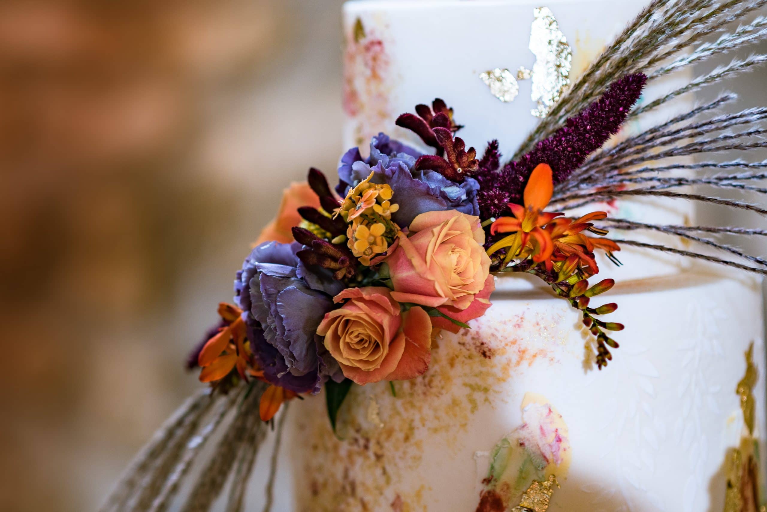 Autumn inspired flowers on the wedding cake captured by Pedge Photography