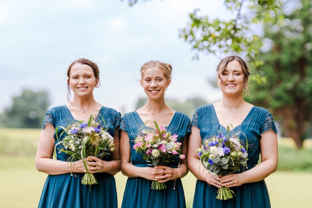 3 lovely Bridesmaids pose for a picture with their flowers on a gorgeous country backdrop, at a Gloucestershire wedding located at Hatherley Manor, Gloucester