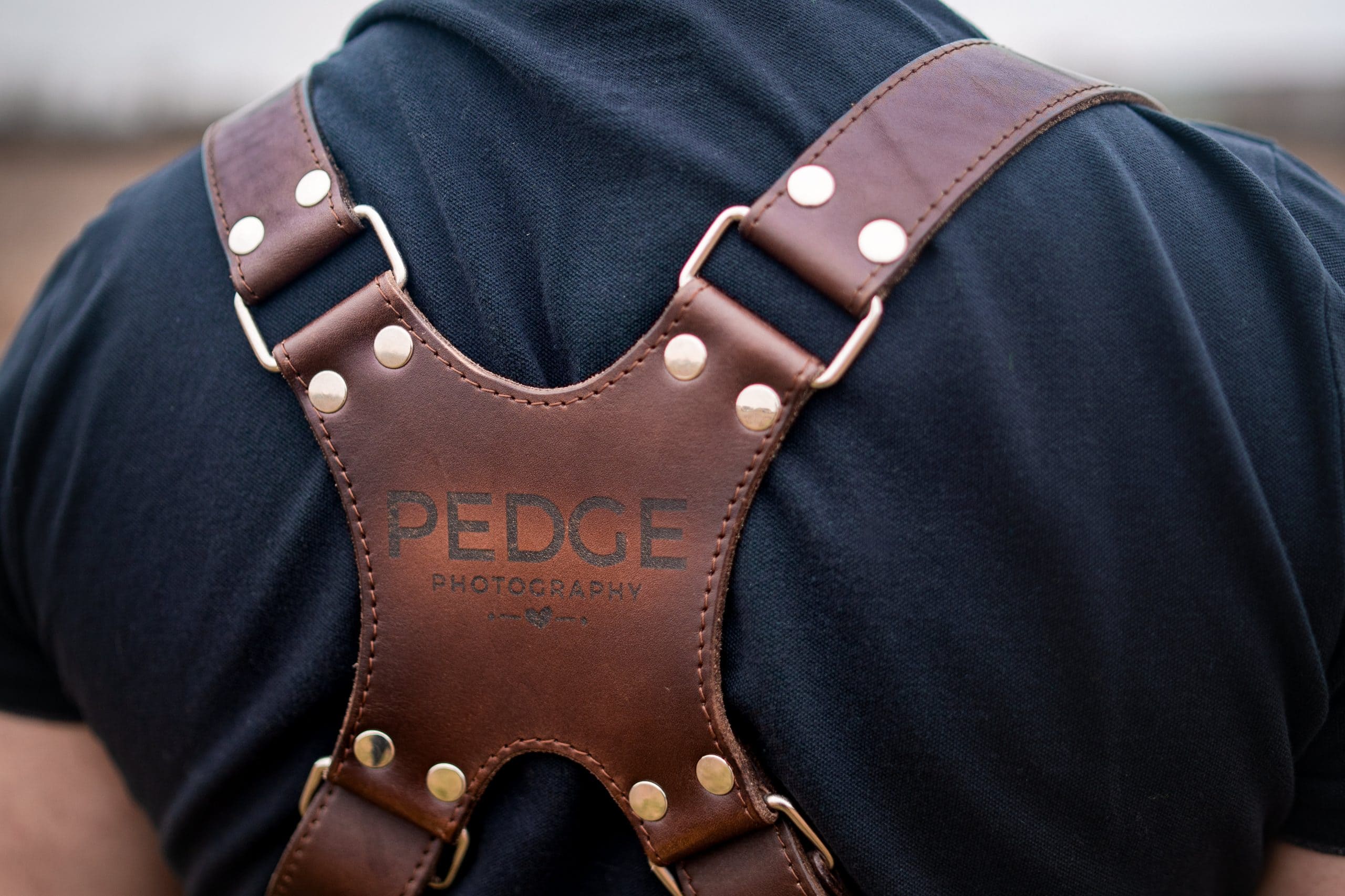 Pedge Photography's dual leather camera holster etched with his company logo.  