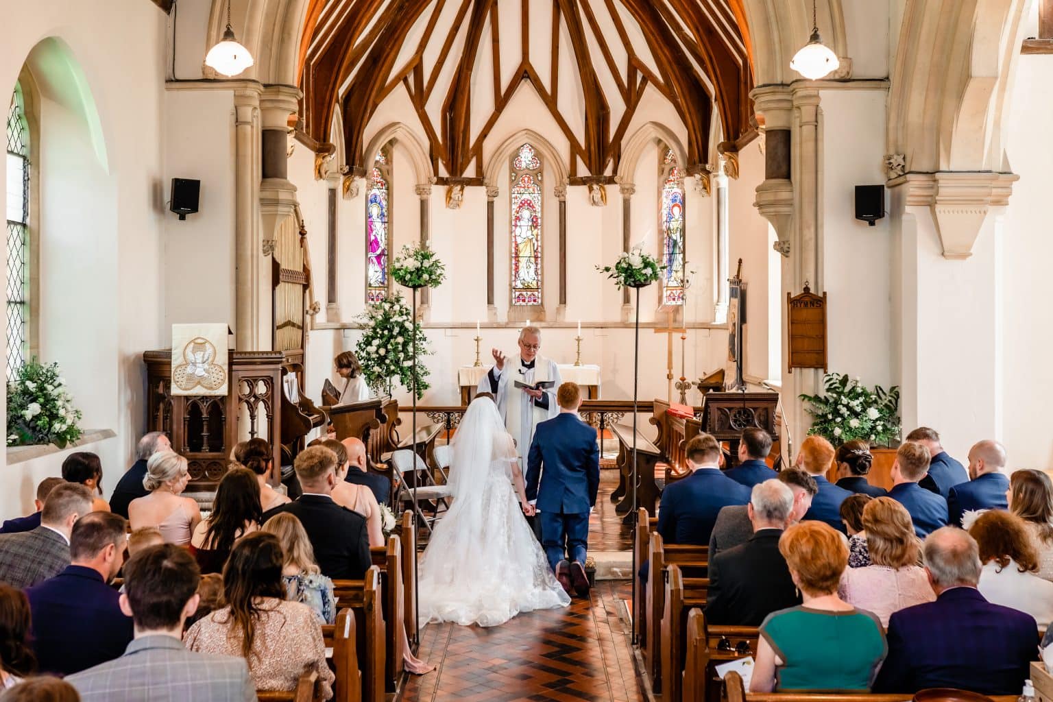 Couple kneeling during ceremony at Christ Church, Gretton