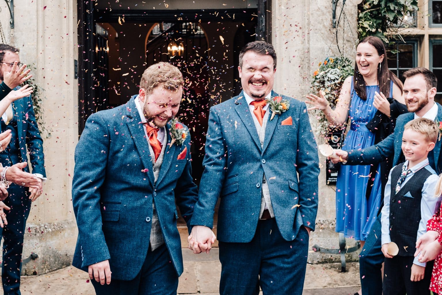 Confetti covers the two grooms at The Hare and Hounds Hotel in Tetbury