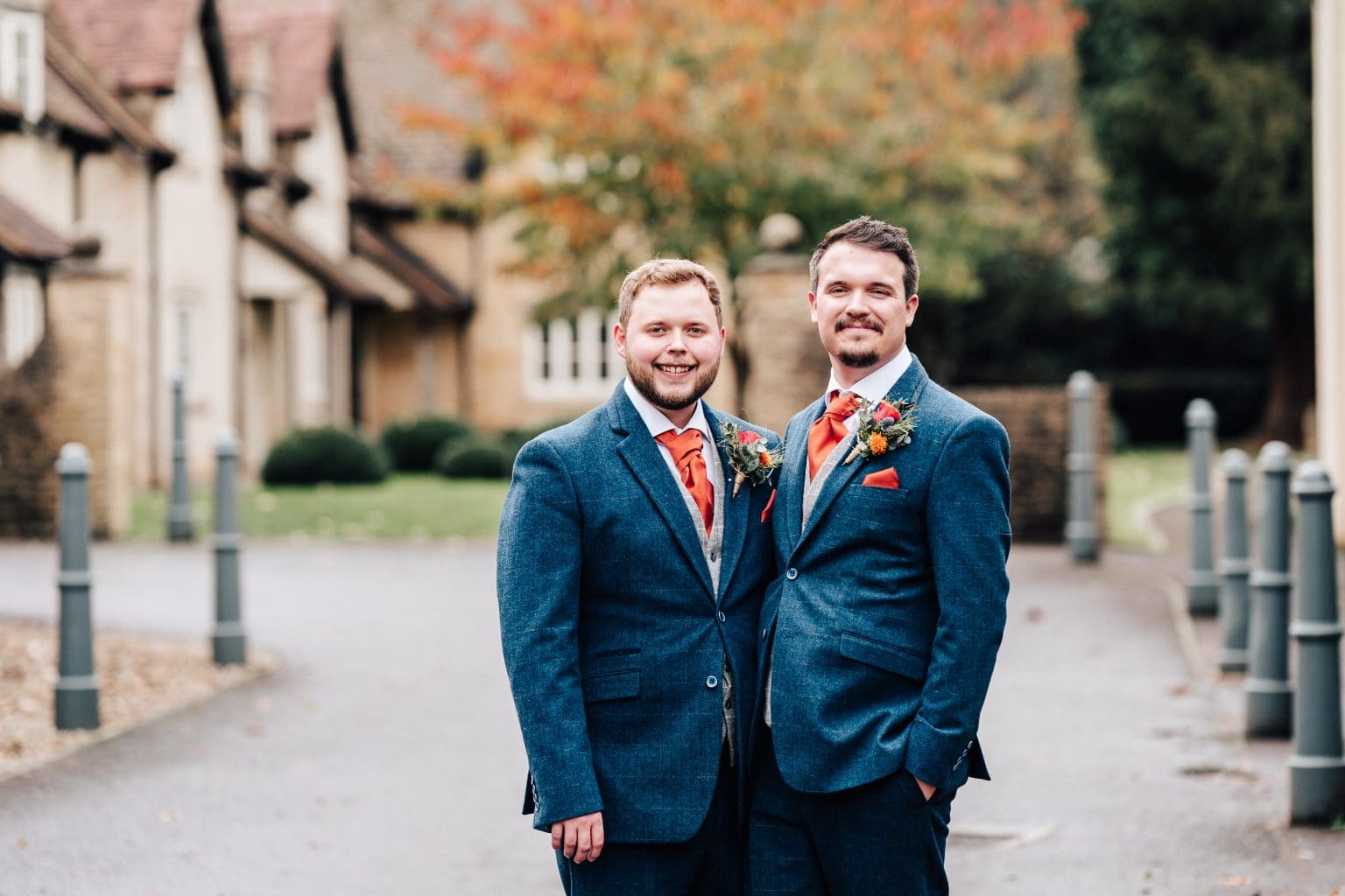 Same sex couple pose for a photo as newlyweds at The Hare and Hounds Hotel Tetbury