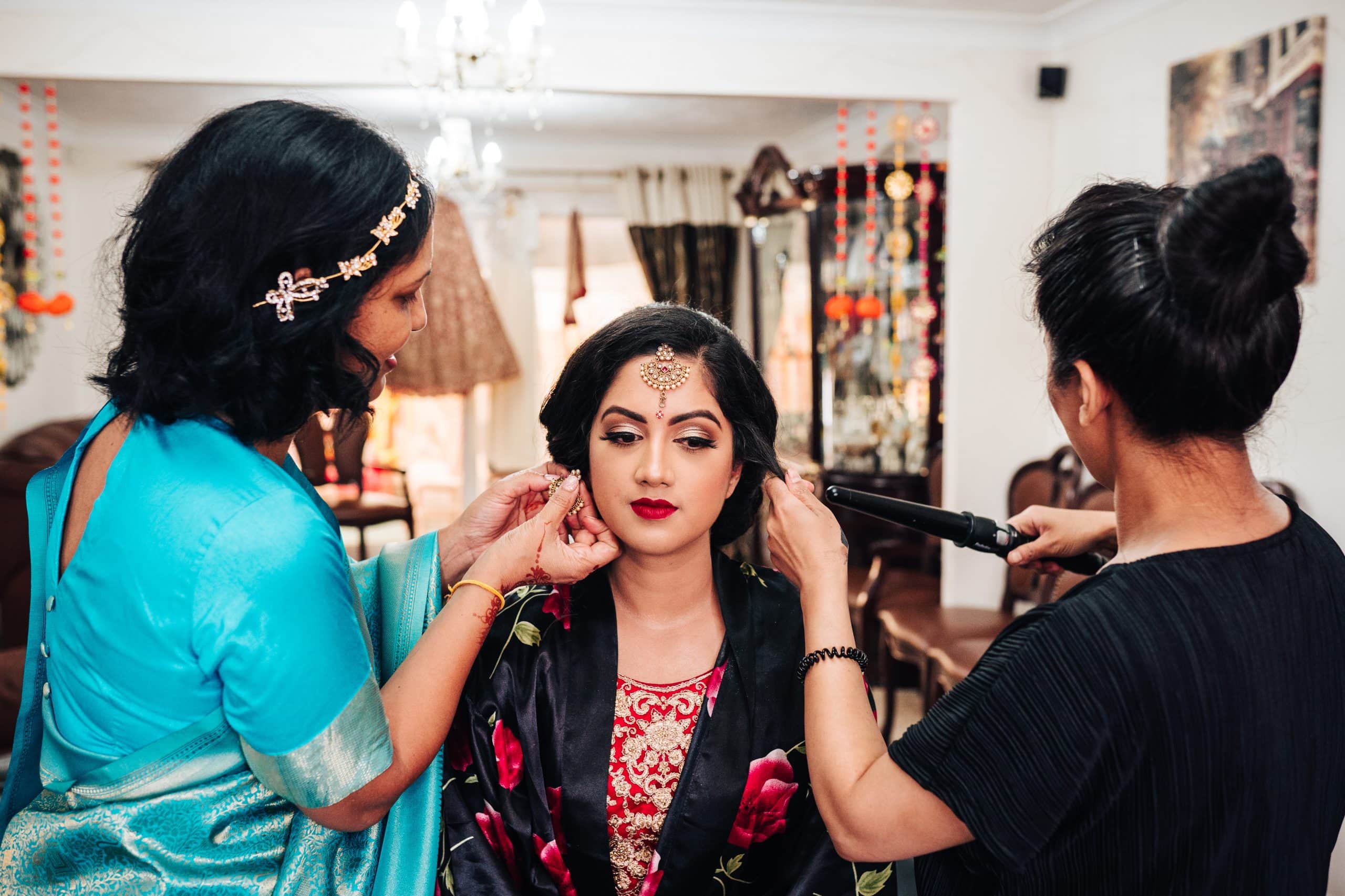 Indian bridal makeup in Gloucester. Mum and makeup artist help with the finishing touches before this bride gets married.