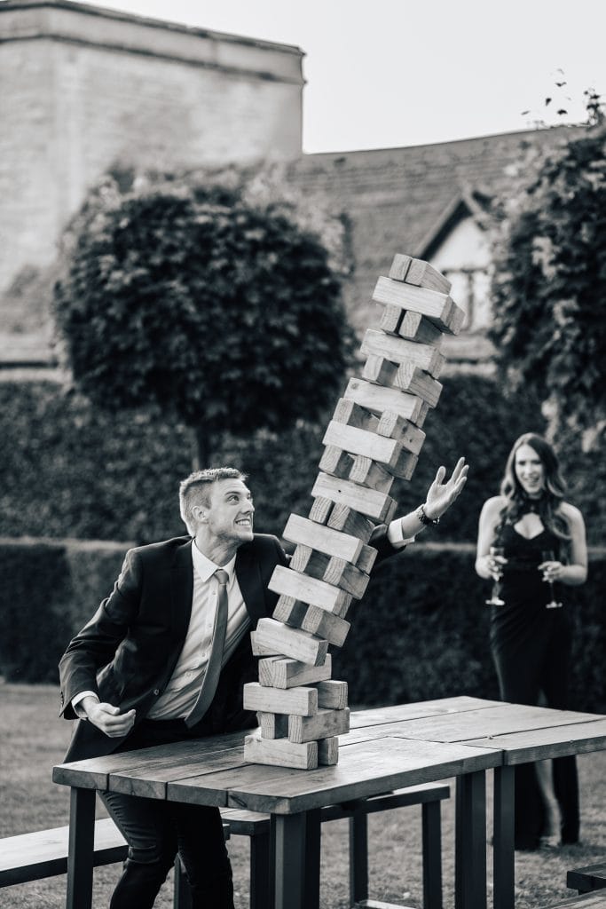 Action shot on a falling jenga block at Ellenborough Park Hotel. There is no saving the tower now as this man tries to stop it from toppling over.