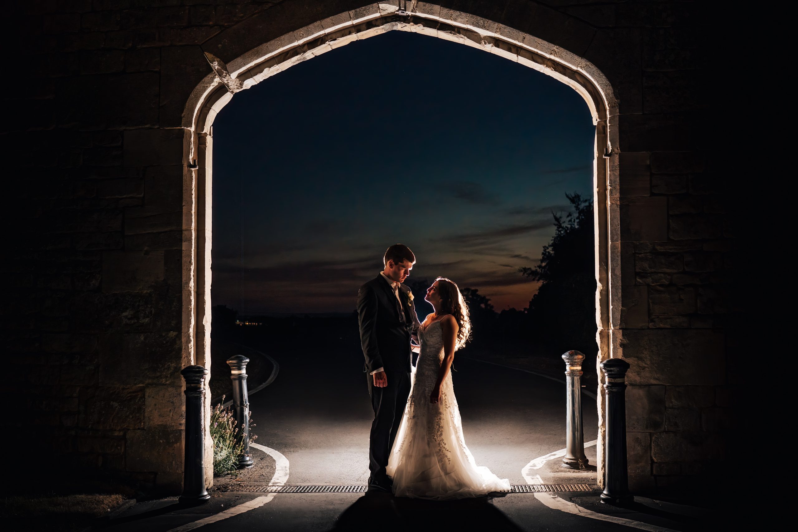 Creative lighting for this wedding couple portrait using flash lighting in the dark. Captured by wedding photographer Ellenborough Park Hotel