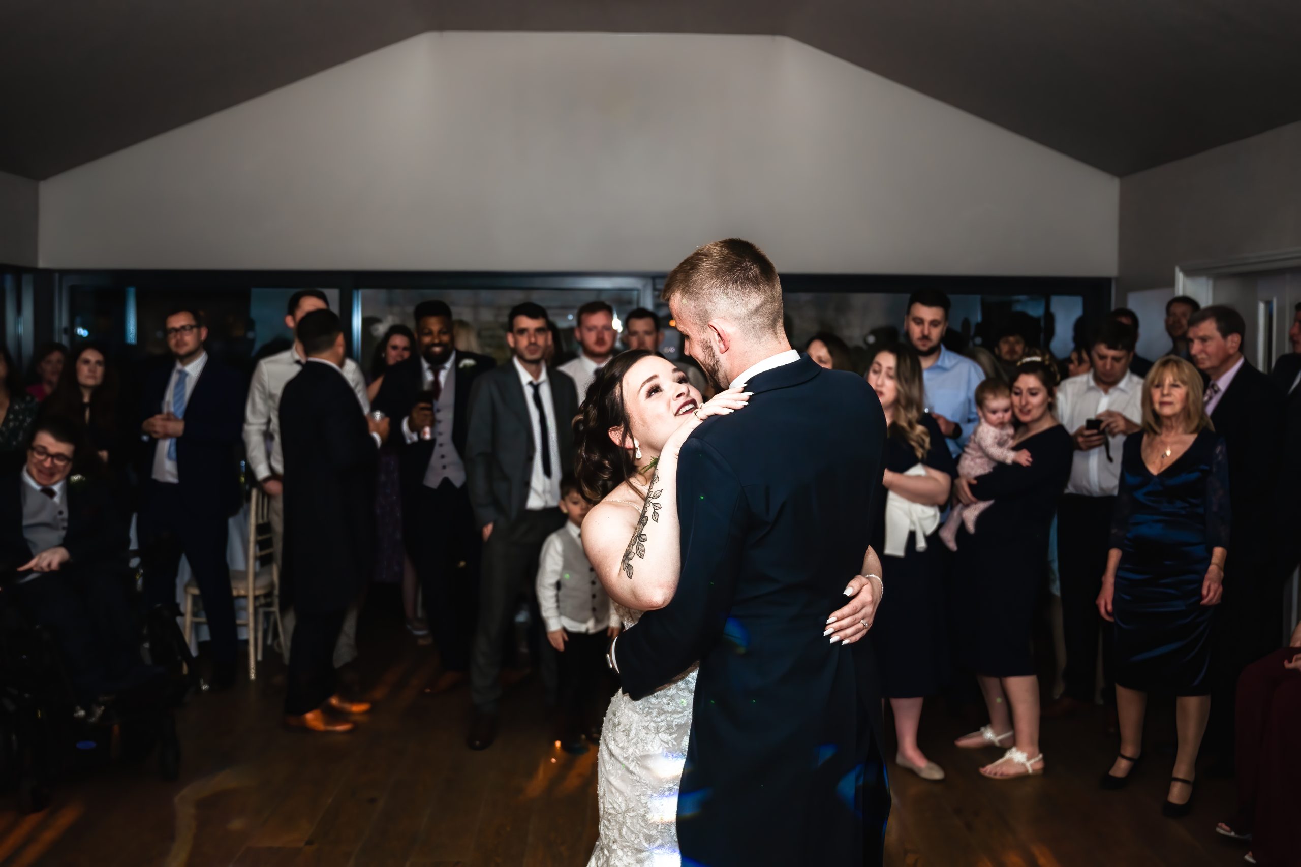 Bride and groom take their first dance whilst their friends and family look on at The Barn at Upcote, Cheltenham